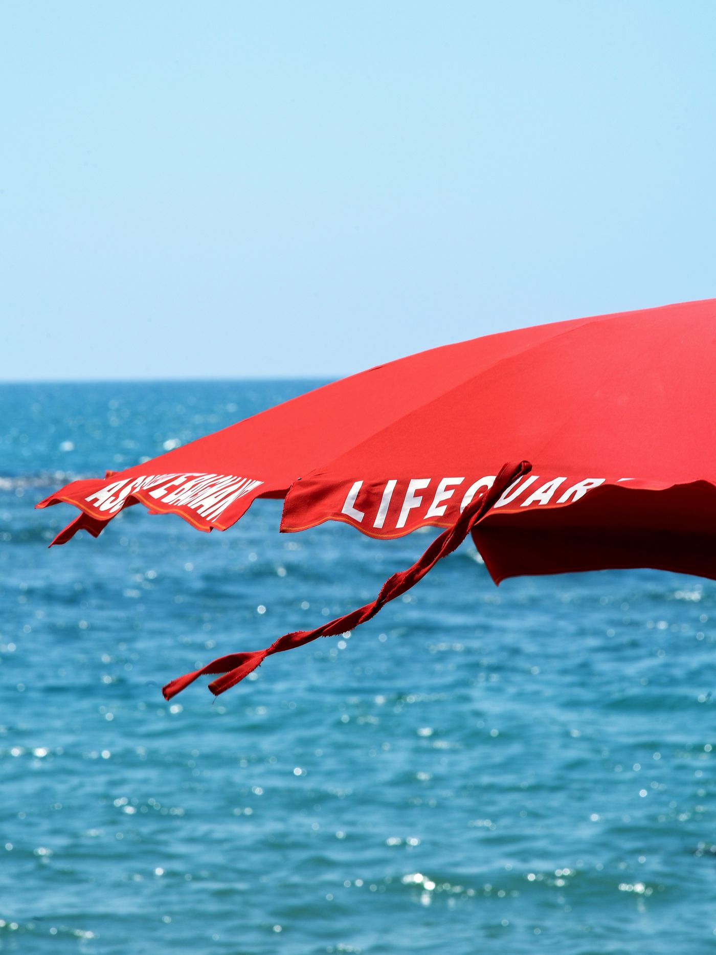 Ombrellone rosso sulla spiaggia del Marechiaro davanti al mare di Lido di Ostia